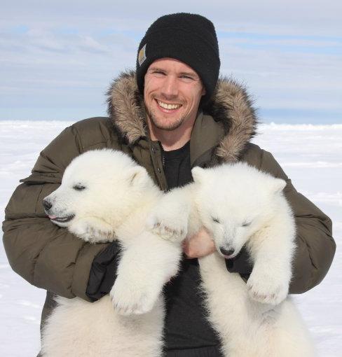John Whiteman holding polar bear cubs